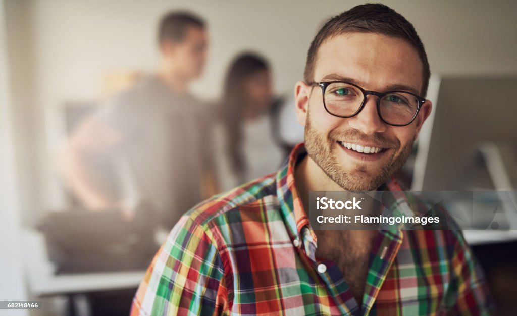 Allegro imprenditore che indossa gli occhiali in ufficio - Foto stock royalty-free di Uomini