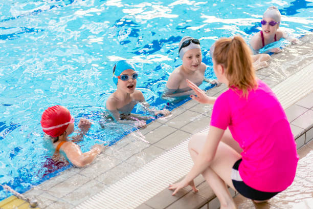 istock happy children kids group at swimming pool class learning to swim 682151134