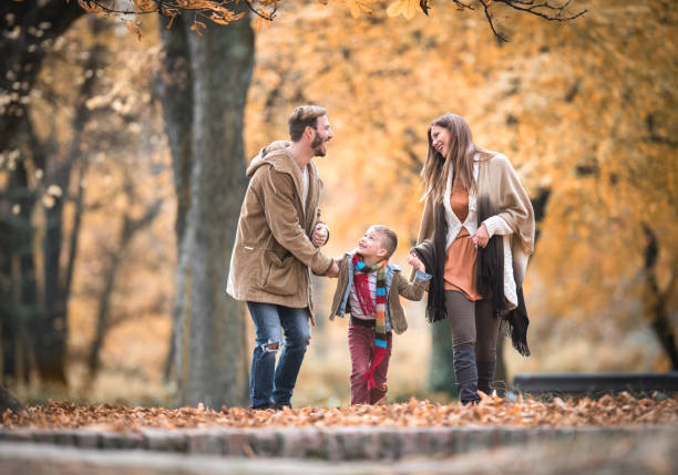 istock Cheerful family holding hands and communicating while walking in autumn day. 682151282