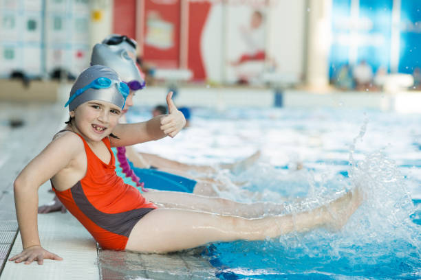 istock happy children kids group at swimming pool class learning to swim 682151400