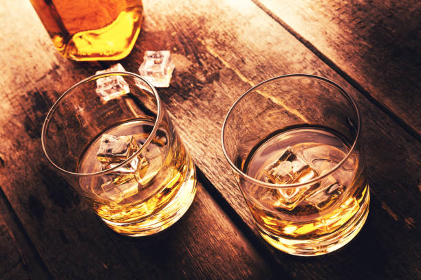 istock whiskey with ice on old dark wooden table 682151522