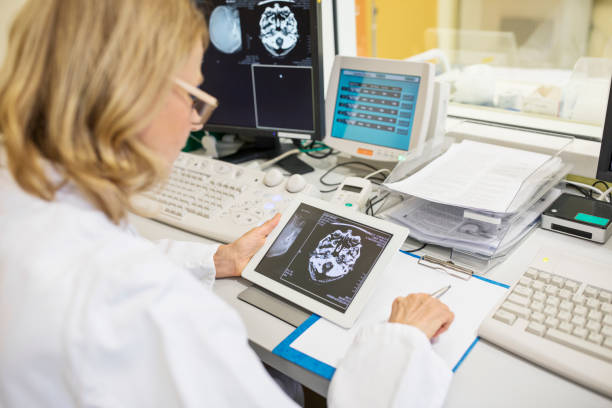 成熟した医者のタブレットで x 線画像を調べる - radiologist cat scan x ray cat scan machine ストックフォトと画像