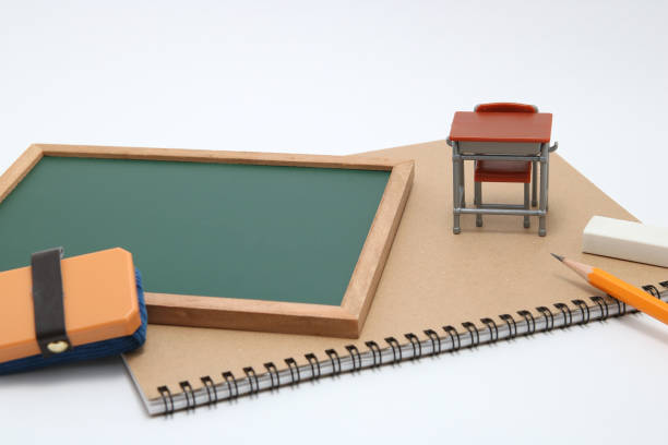 istock Miniature school desk, chalkboard and notebook on white background. 682154720