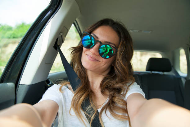 Beautiful young woman in car stock photo