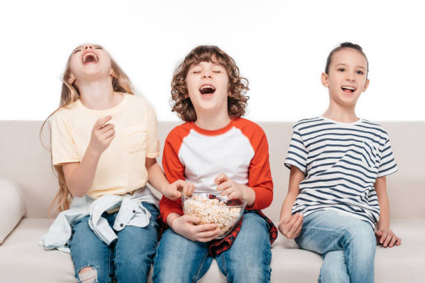 istock Cute children on couch with popcorn 682158924