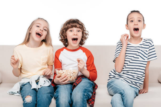 istock Cute children on couch with popcorn 682159364