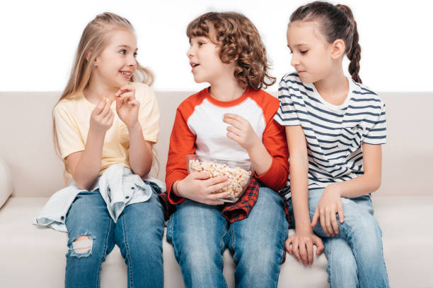 istock Cute children on couch with popcorn 682162220