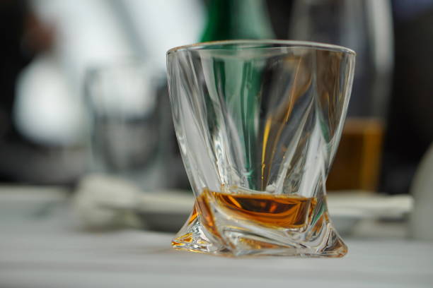 istock Modern fancy whiskey glass with golden alcoholic beverage on a white tablecloth surface as a symbol of drinking alcohol 682162778