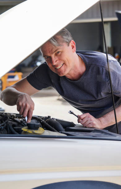 istock Fifty year-old man working on his car and smiling 682168728