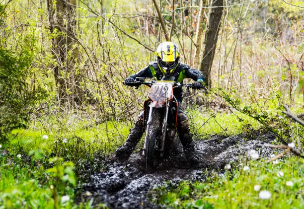 Photo of Young dirt biker getting through a muddy spot