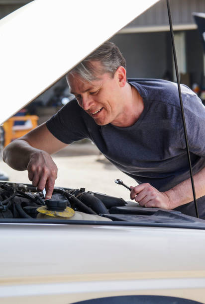 istock Fifty year-old man working on his car and smiling 682171194
