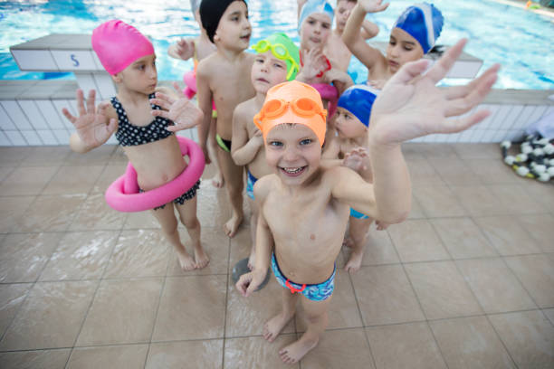 istock happy children kids group at swimming pool class learning to swim 682171588