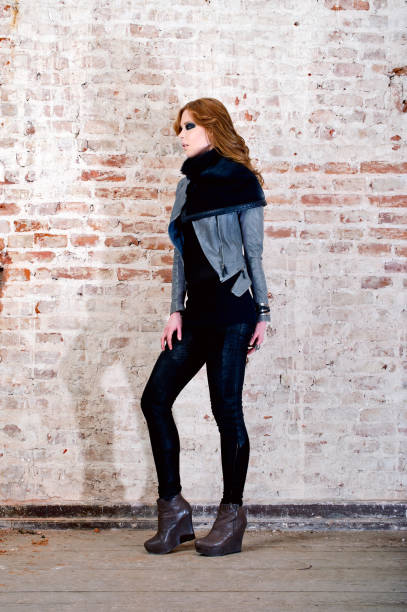 istock beautiful red head woman posing in leather jacket and black pant 682172502