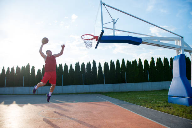 istock Young man jumping and making a fantastic slam dunk playing streeball 682179276