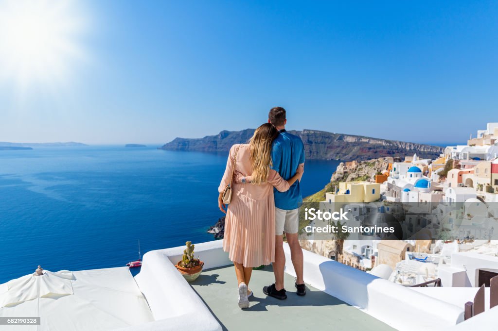 Young couple on island of Santorini Young couple  on the roof of the building in Santorini, Greece. Couple - Relationship Stock Photo