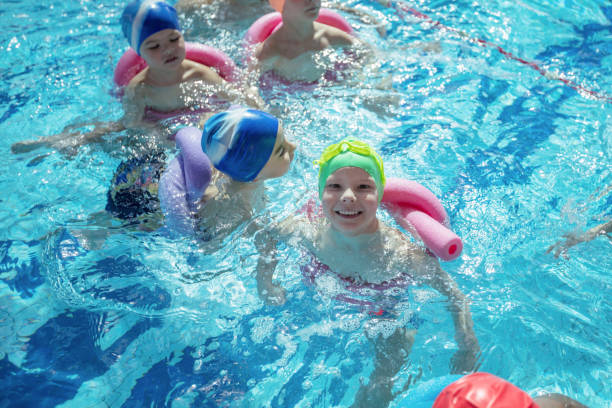 istock happy children kids group at swimming pool class learning to swim 682193650