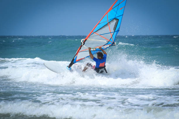 nice mail sportsman windsurfer nice strong mail sportman doing windsurf and looking in front of him seriously and with attention mistral wind stock pictures, royalty-free photos & images