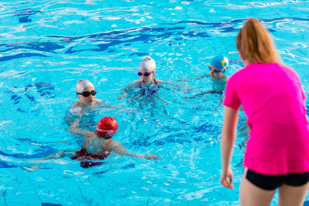 istock happy children kids group at swimming pool class learning to swim 682196794