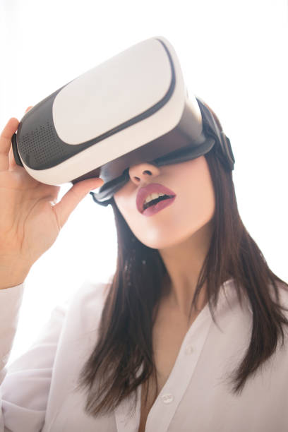 istock Excited young woman in VR glasses enjoying simulation 682198356
