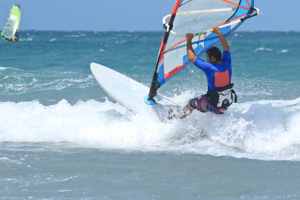 nice mail sportsman windsurfer nice strong mail sportman doing windsurf and looking in front of him seriously and with attention mistral wind stock pictures, royalty-free photos & images
