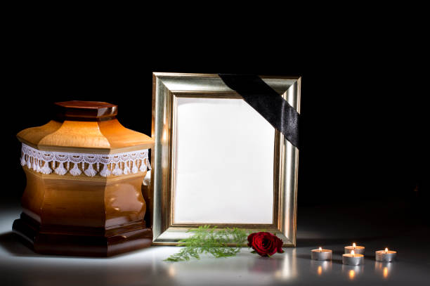 istock Wooden cemetery urn with mourning frame and flower, candl 682200518