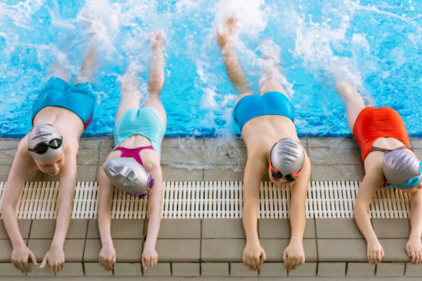 istock happy children kids group at swimming pool class learning to swim 682204146