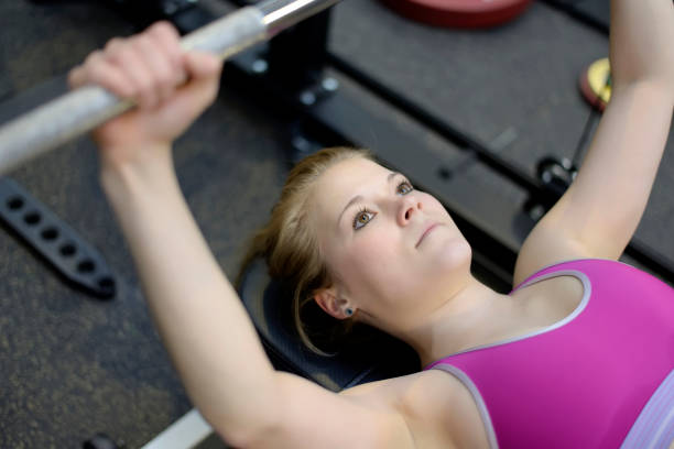 istock woman lifting weights in gym 682222550