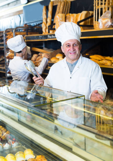 istock staff offering fresh baguettes 682222596