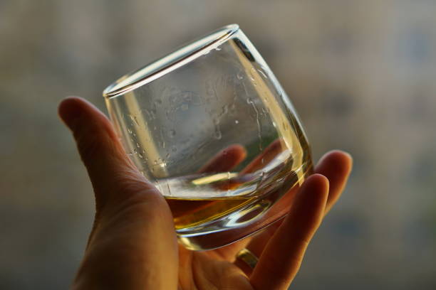 istock Male hand holding a whiskey glass with golden liquo 682222708
