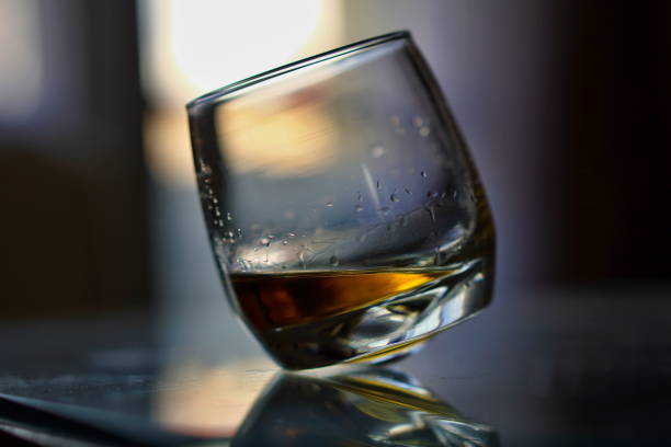 istock Off-balanced whiskey glass with golden liquor 682222764