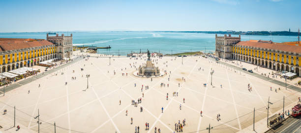Lisbon aerial panorama over Praco do Comercio waterfront square Portugal Aerial panorama overlooking the crowds of tourists enjoying the warm sunshine in the Praca do Comercio, the landmark square beside the River Tagus waterfront in the heart of Lisbon, Portugal’s vibrant capital city. lisbon photos stock pictures, royalty-free photos & images