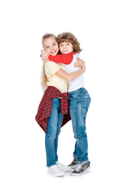 A child boy posing on studio white background with sister
