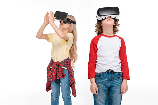 Boy and girl using virtual reality headsets isolated