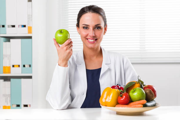 istock Female nutritionist holding a green apple 682236414