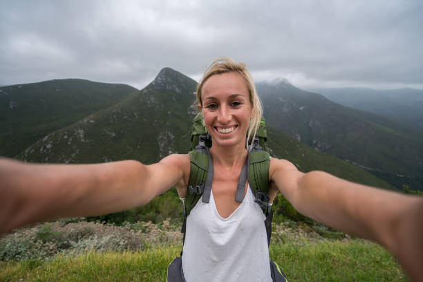 istock One young woman taking selfie with mountain landscape 682236558