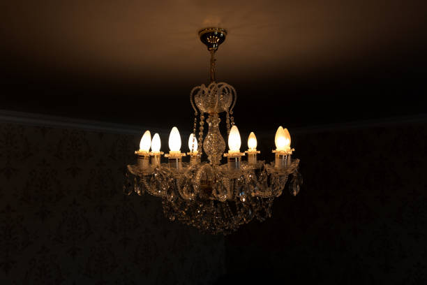 istock A burning light bulb on a crystal chandelier on a dark background 682236682