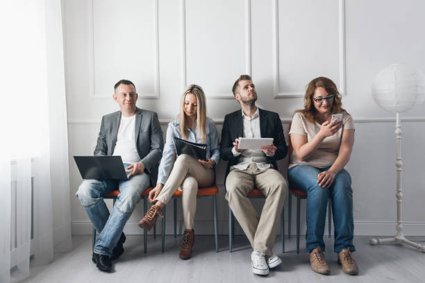 istock Group of creative people sitting on chairs in waiting room 682239634