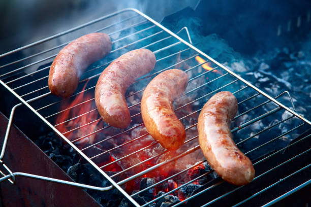 燃えるような石炭と食欲をそそる 4 ジューシーなソーセージのバーベキュー グリルします。 - sausage bratwurst barbecue grill barbecue ストックフォトと画像
