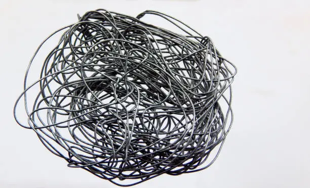 Photo of metallic wire tangled on white