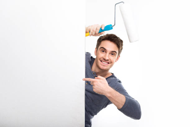 istock handsome man holding paint roller and pointing on blank card isolated on white, handyman tools concept 682261208