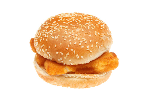 Fish burger, fish fingers in a seeded burger bun isolated against white
