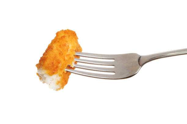 Fish finger on a fork Fish finger on a fork isolated against white fish stick stock pictures, royalty-free photos & images