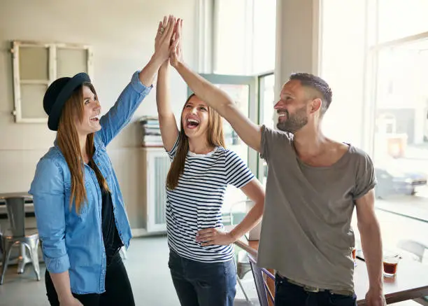 Photo of Group of people making high five gesture