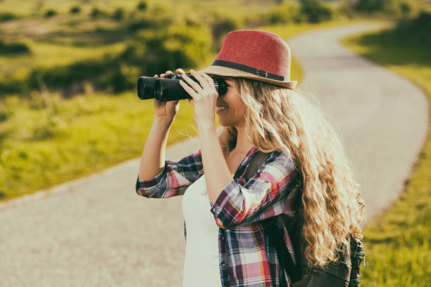istock Woman using binoculars at the country road 682282674