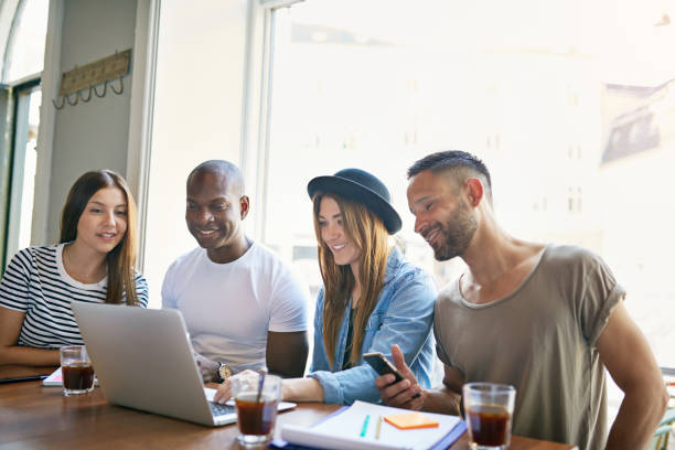 istock Four stylish adults sitting at desktop watching 682282720