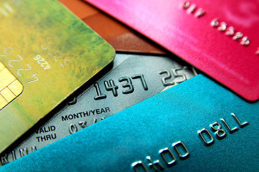 Stack of multicolored credit cards close-up view with selective focus.