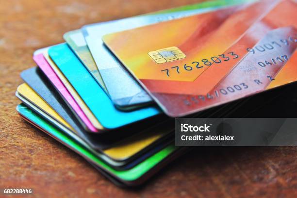 Montón De Tarjetas De Crédito Multicolores Sobre Un Fondo De Madera Foto de stock y más banco de imágenes de Tarjeta de crédito