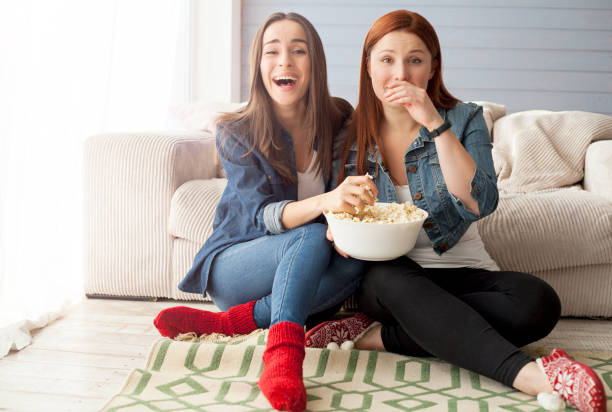istock Girlfriend watching a very funny movie and eat popcorn. 682291896