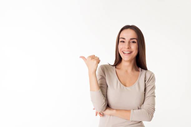 istock Confident attractive young woman points to the zone for advertising. 682292068