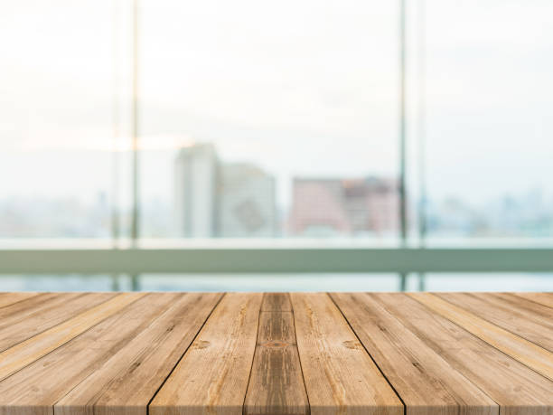 istock Wooden board empty table top blurred background. Perspective brown wood table over blur city building view background - can be used mock up for montage products display or design key visual layout. 682296544